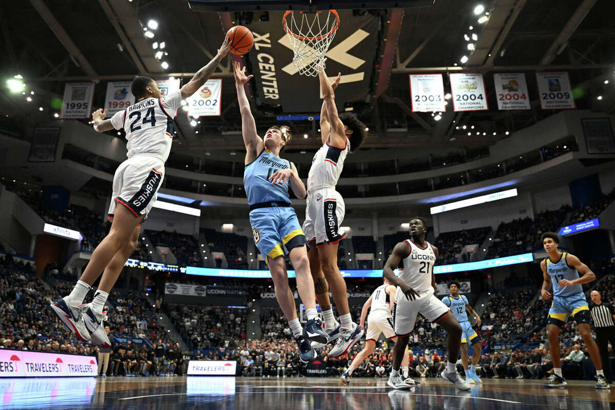 UConn's Jordan Hawkins (24) blocks a shot by Marquette's Tyler Kolek (11) in the first half of an NCAA college basketball game, Tuesday, Feb. 7, 2023, in Hartford, Conn. (AP Photo/Jessica Hill)