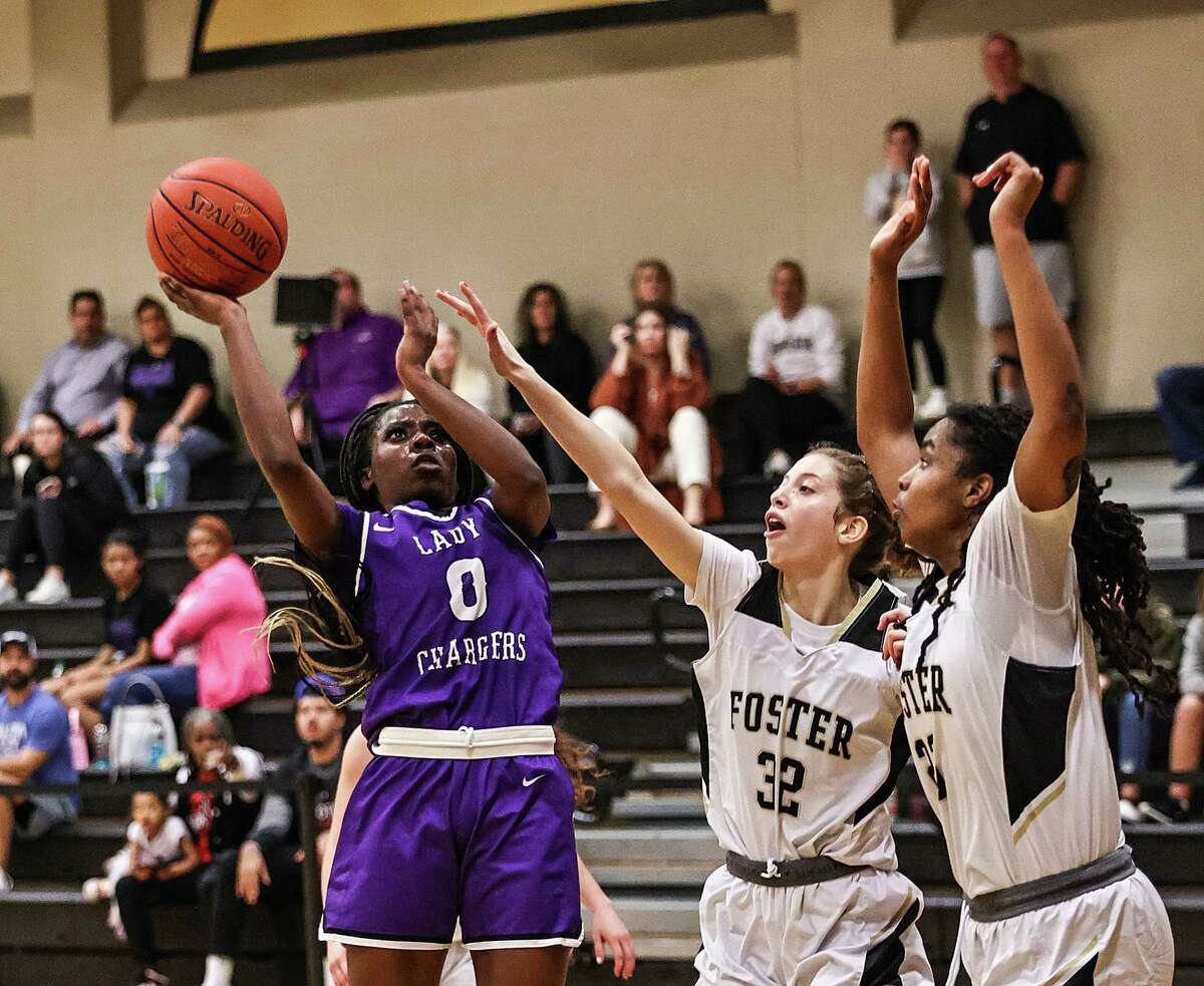 Fulshear's Ruke Ogbevire (0) drives to the basket as Foster's Audrey Adams (32) and Kailani Lindsey (23) defend during Tuesday's District 20-5A girls basketball game in Richmond.