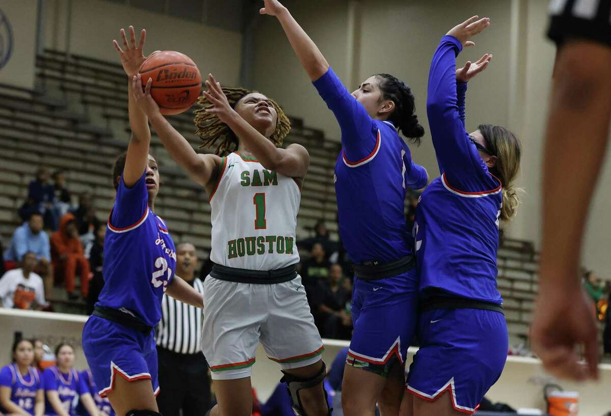 Sam Houston’s Cheyenne Mitchell (01) drives to the basket against Jefferson’s Kathleen Santos (23), Amarys Cuellar and Alyssa Reyna (22) during their girls basketball at Alamo Convocation Center on Tuesday, Feb. 7, 2023.
