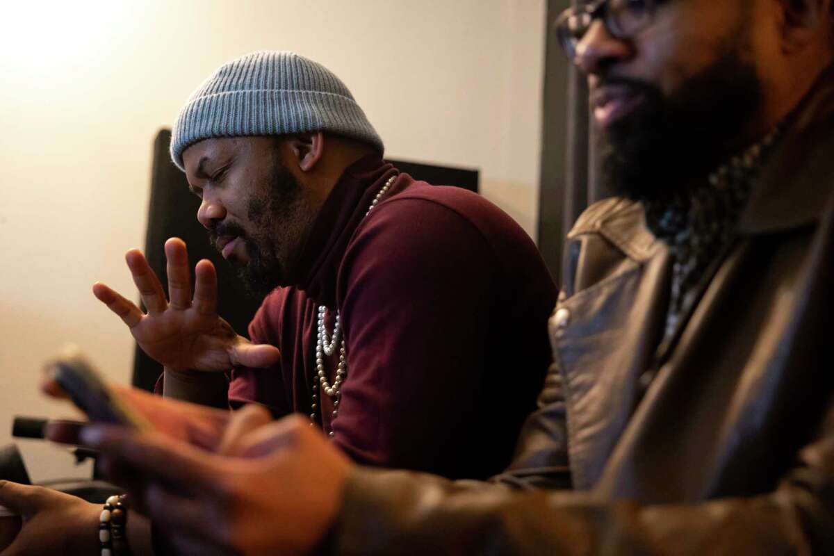 Houston Poet Laureate Emanuelee Bean, known as “Outspoken Bean” listens to his new project “Space City Mixtape” with producer and friend Russell Guess in Guess’s studio on Monday, Feb. 6, 2023.