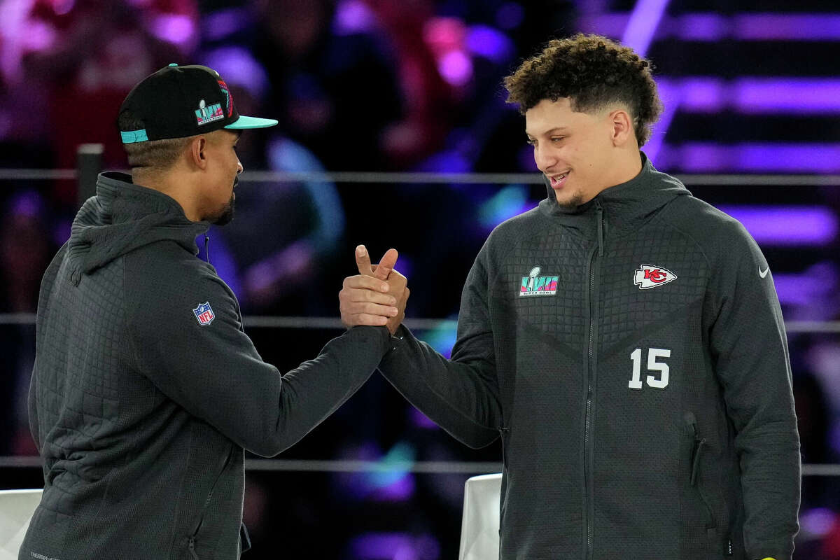 Philadelphia Eagles quarterback Jalen Hurts, left, and Kansas City Chiefs quarterback Patrick Mahomes shake hands during the NFL football Super Bowl 57 opening night, Monday, Feb. 6, 2023, in Phoenix. This will be the first Super Bowl featuring two starting quarterbacks from Texas.