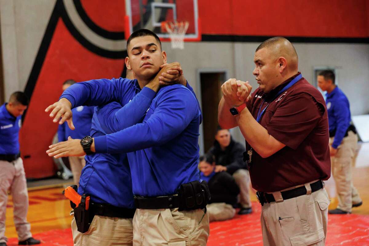 Antonio Quiroga practices a headlock on Keith Delgado as Uvalde County Constable Emmanuel Zamora, an instructor, gives him feedback during police academy training Nov. 15 at Southwest Texas Junior College in Uvalde. The Uvalde school district is rebuilding its police force but dropped a planned private investigation of its performance at the May 24 mass shooting at Robb Elementary School.