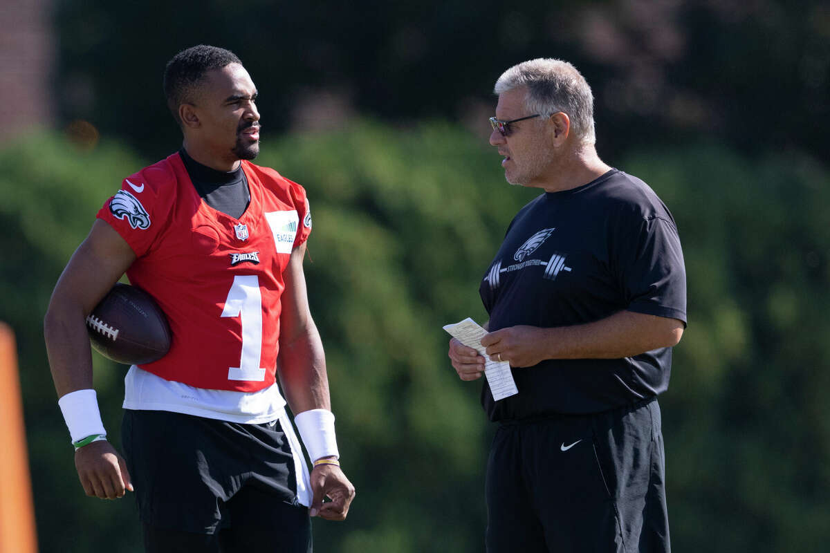 PHILADELPHIA, PA - AUGUST 05: Jalen Hurts #1 of the Philadelphia Eagles talks to offensive line coach Jeff Stoutland during training camp at the NovaCare Complex on August 5, 2021 in Philadelphia, Pennsylvania. (Photo by Mitchell Leff/Getty Images)