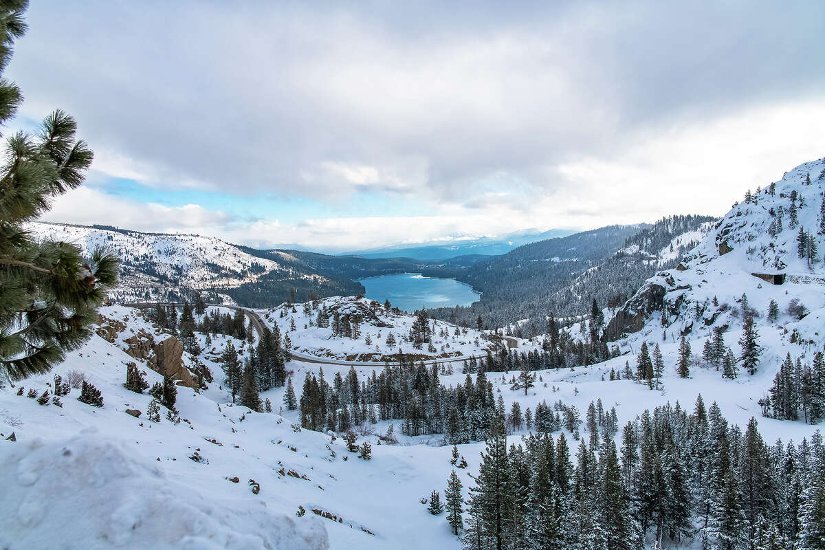 FILE: Donner Lake under snow in winter, with train tunnels in the mountain.