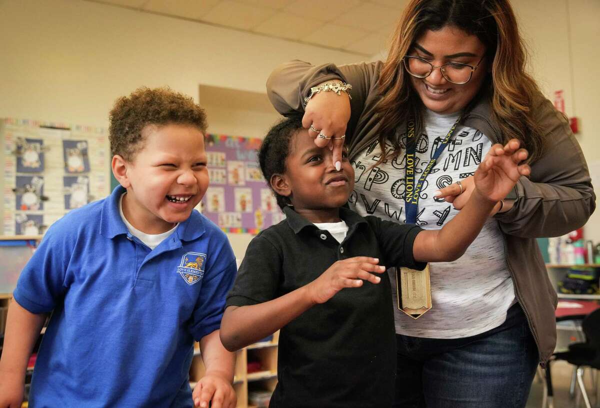 Cynthia Miranda jokes with Khalil Frazier, 5, center and Famous Oye, 4, during a “wiggle break” on Wednesday, Feb. 8, 2023, at Love Elementary School in Houston.