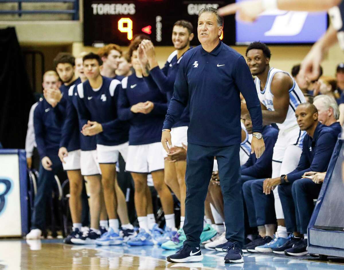 San Diego head coach Steve Lavin and players celebrate after a Toreros 3-pointer against the Utah State Aggies at the Jenny Craig Pavilion on Thursday, Nov. 17, 2022 in San Diego.