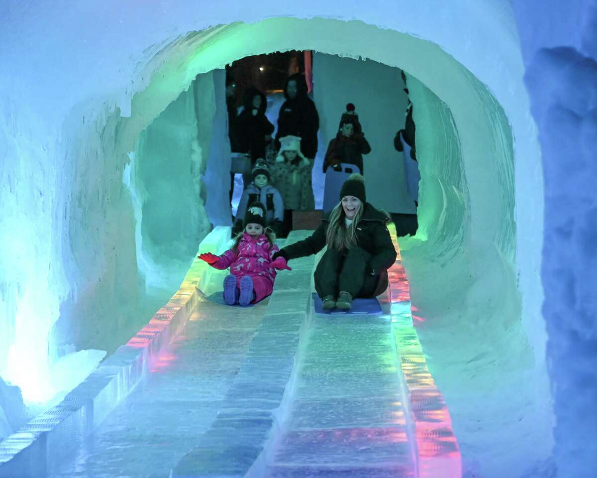 Amanda and Alessandra Hart slide down an ice slide at the Ice Castles exhibit on Wednesday, Feb. 8, 2023, in Lake George, NY.
