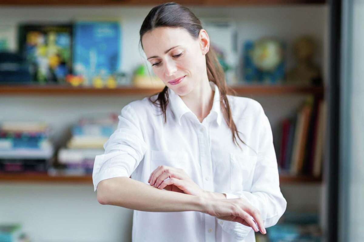 Woman itching her arm.