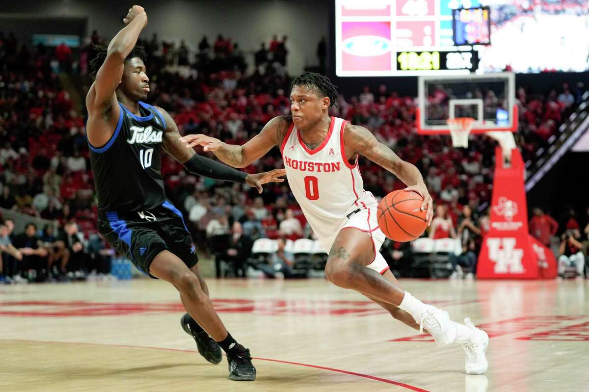 Houston guard Marcus Sasser (0) dribbles the ball as Tulsa forward Tim Dalger defends during the second half of an NCAA college basketball game Wednesday, Feb. 8, 2023, in Houston.
