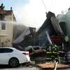 2023年2月9日星期四，加利福尼亚州旧金山，消防员在第22大道的第三次火警中灭火，因为他们的建筑似乎倒塌了，邻居的房屋窗户被炸毁了。