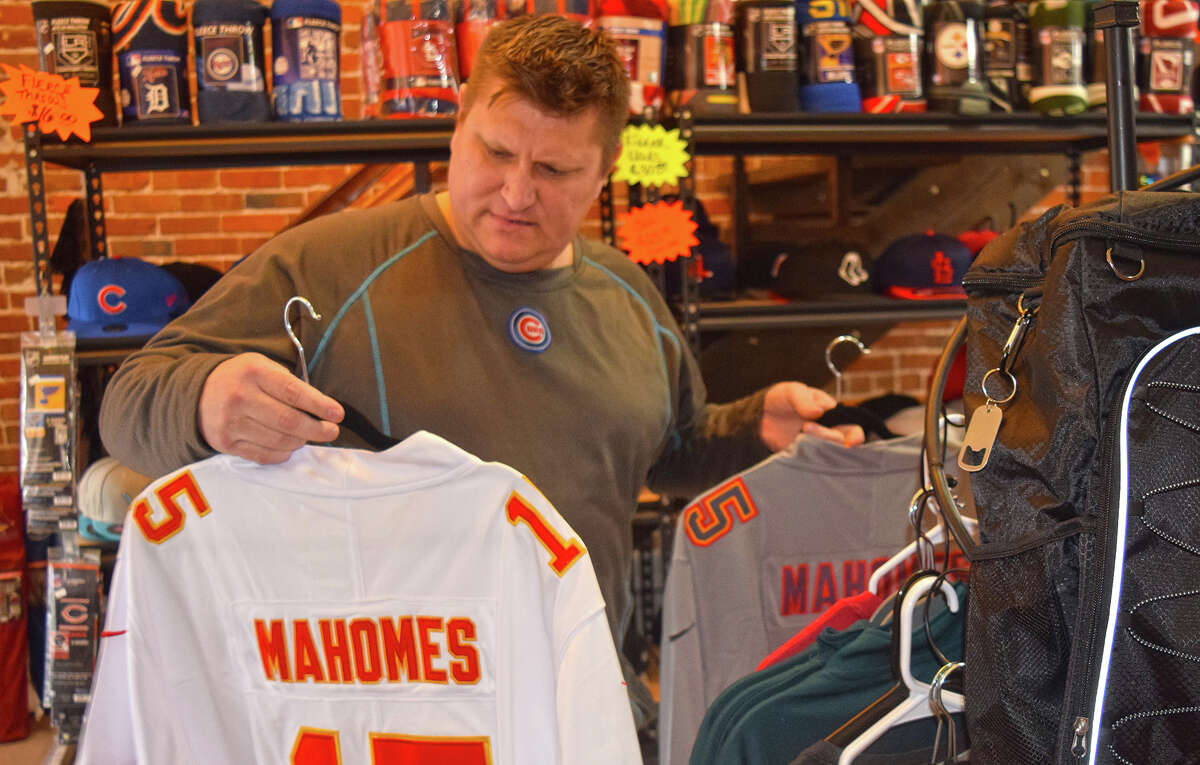 Billy McCurley, owner of The Sports Zone in downtown Jacksonville, inspects two versions of the jersey worn by Kansas City Chiefs quarterback Patrick Mahomes. Based on souvenir sales at the store, rooting interest in Sunday's Super Bowl between the Chiefs and the Philadelphia Eagles is about even.