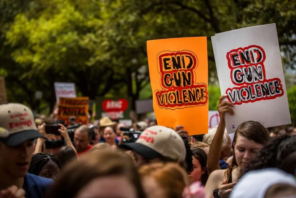 People hold signs in support of ending gun violence during a March for Our Lives event at the state Capitol in Austin on March 24, 2018. 