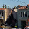 Firefighters stand on an adjoining structure from a home on the 1700 block of 22nd Avenue in the Sunset District that completely collapsed after a fire consumed the structure in San Francisco, Calif. on Feb. 9, 2023.