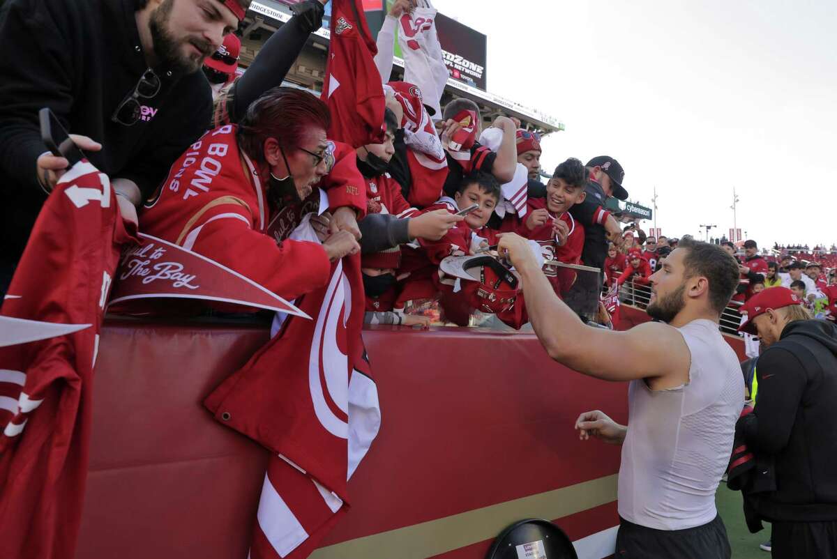 Nick Bosa, shown signing autographs before a game against the Texans on Jan. 2, 2022, was voted the NFL's Defensive Player of the Year.