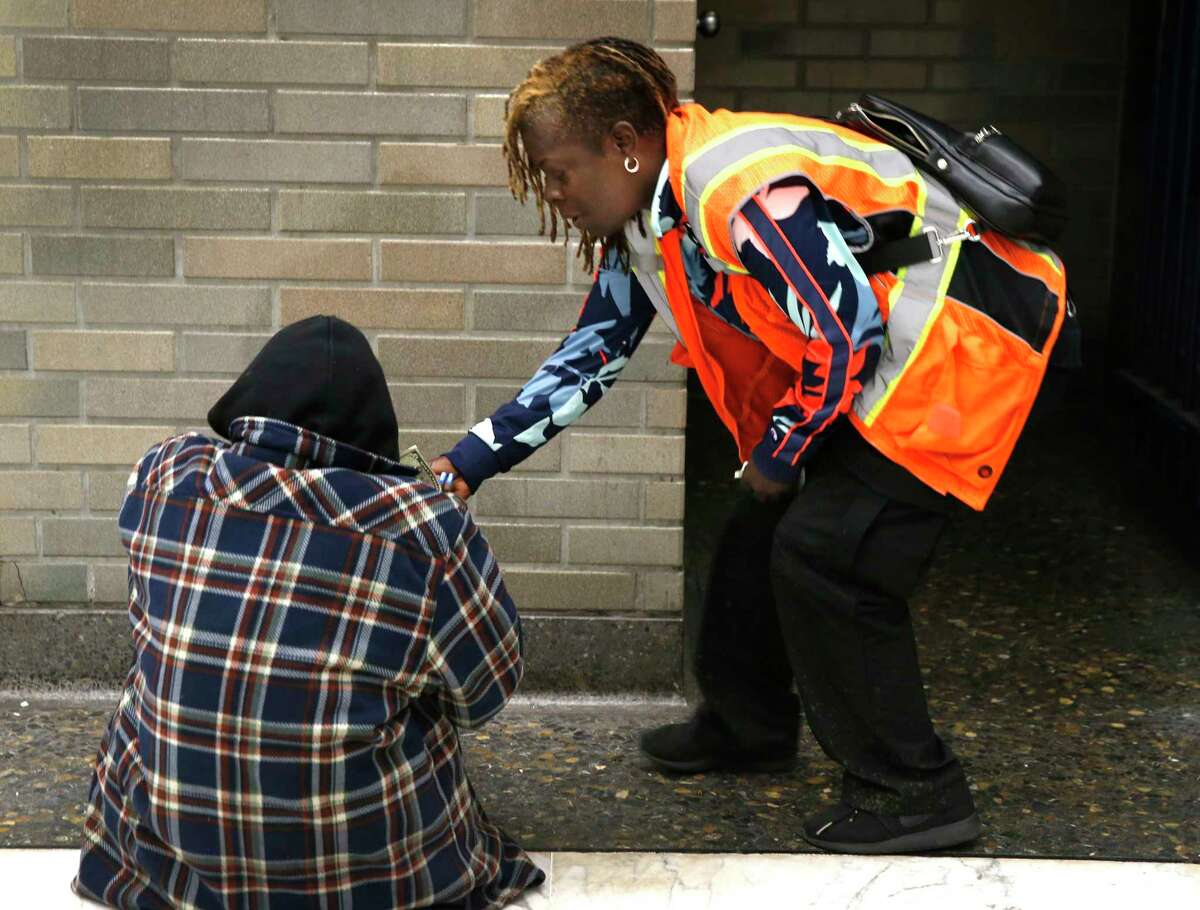 Cherie Pittman, who has been homeless, assists a man who was cited for fare evasion, before taking him to street level in San Francisco in 2019. BART partnered with the Salvation Army to launch a program to fight homelessness, but it only served one person in two years.