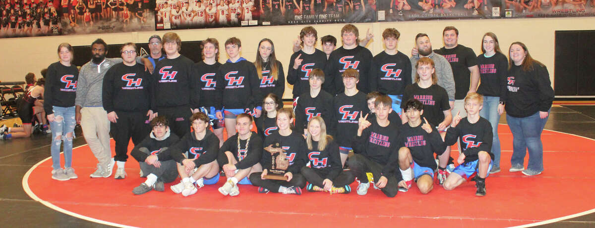 Chippewa Hills' wrestling team celebrates another district championship trophy.