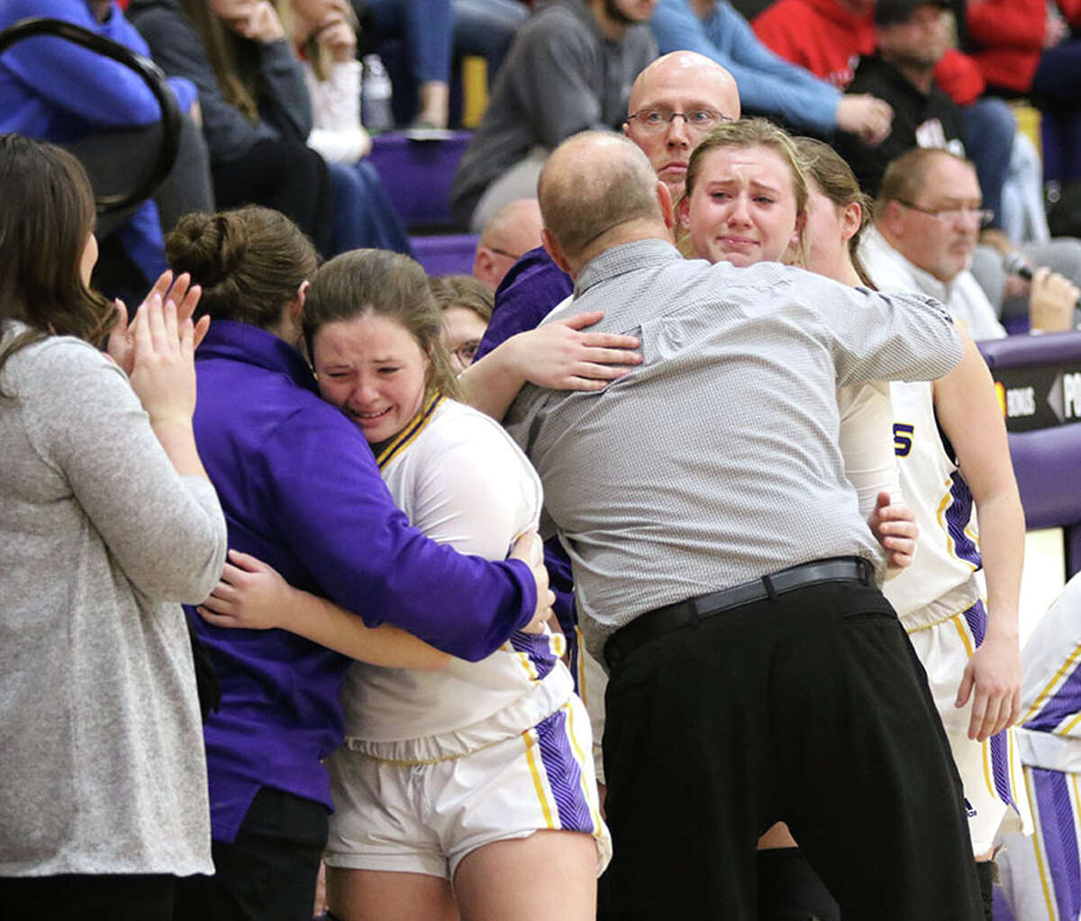 CM senior Aubree Wallace (left) gets a hug from assistant coach Taylor Bedar while coach Mike Arbuthnot hugs senior Olivia Durbin as the come off the court for the last time in their last home game on Monday night in Bethalto.