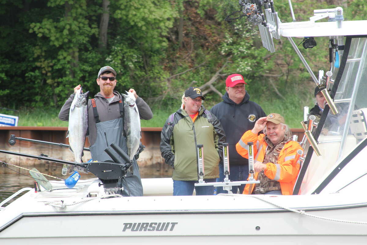 Veterans hold up their catch at the 2022 Tight Line for Troops fishing tournament in Manistee. 