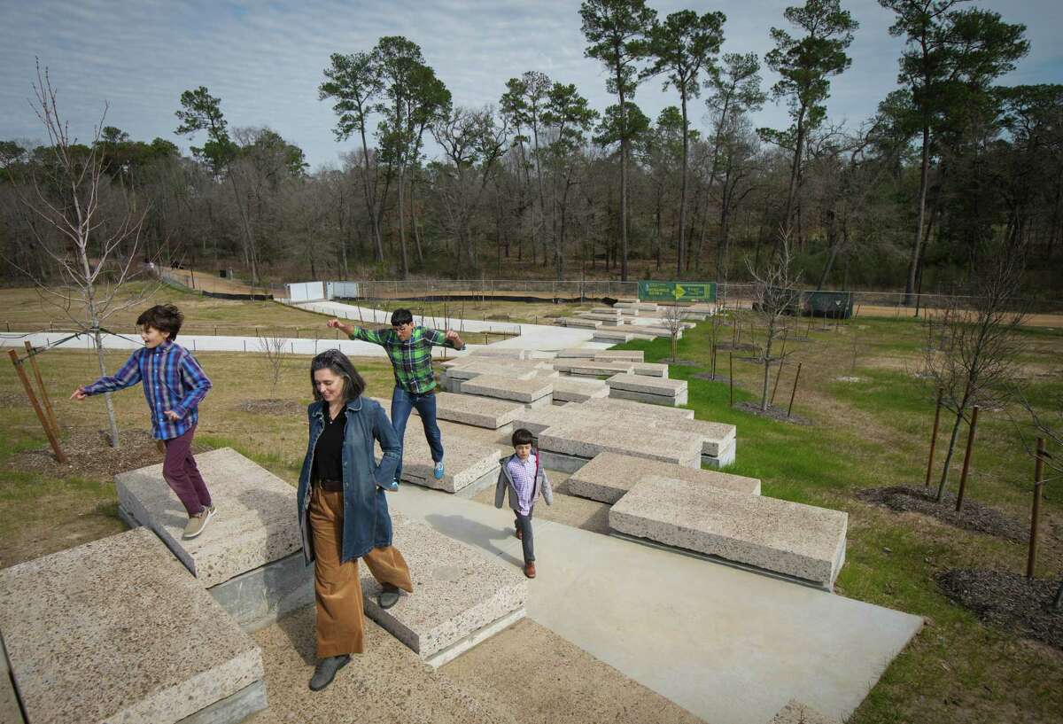 Kate Tabony, front, traverses the Emily Clay Family Scramble with her son Evander, 8, left, husband Freeman, rear, and son Isaac, 6, on the Kinder Land Bridge at Memorial Park in Houston. Kate Tabony was the project manager from the Nelson Byrd Woltz architecture firm that created the land bridge. “It’s pretty magical,” she said. “Seeing it finally finished is really amazing.”