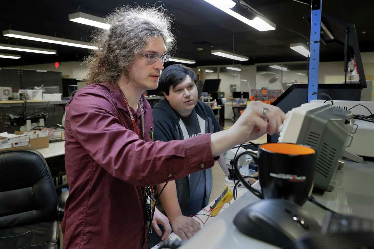 Will Morse, left, and Joe Callahan, right, check circuitry on components at the Nauticus Robotics offices Friday, Feb. 10, 2023 in Webster, TX.