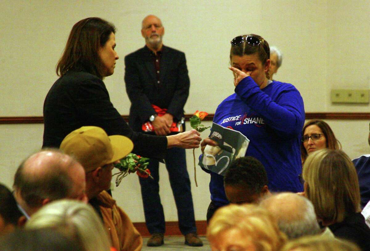 Laura Slinsky, whose son Shane was murdered in 2016, wipes away a tear as Michele Voigt, with Moms Demand Action for Gun Sense in America, hands her an orange rose during a special state-wide event hosted at the Margaret Morton Government Center in downtown Bridgeport, Conn., on Saturday Feb. 8, 2020. The event concluded a weeklong series of local events in recognition of National Survivors Week, February 1st - 8th. It also featured a Moments That Survive Story Wall, a display of photos and personal stories from Connecticut gun violence survivors that illustrate the effect gun violence has had on their lives.