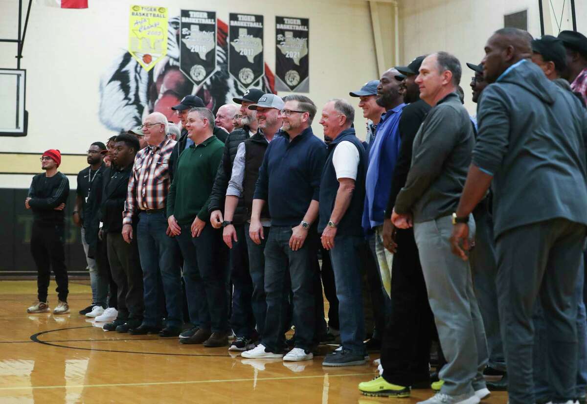 Former members of the Conroe High School boys basketball team gather at halftime of the final game at “The Pit” gymnasium, Friday, Feb. 10, 2023, in Conroe.