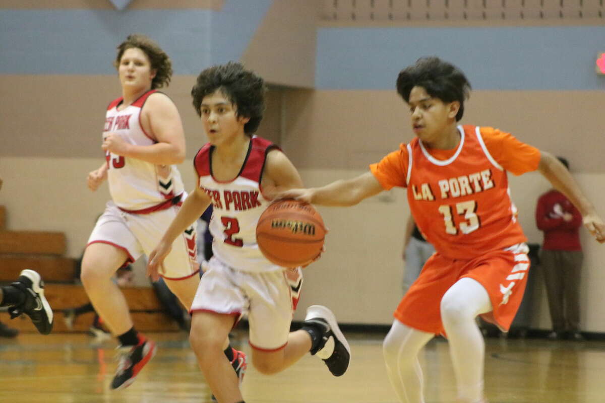 A La Porte Junior High defender is about to steal the basketball from Deer Park Junior High 8B ballhandler Julian Alvarado (2) during their Bay Area League playoff contest in Pearland Friday night.