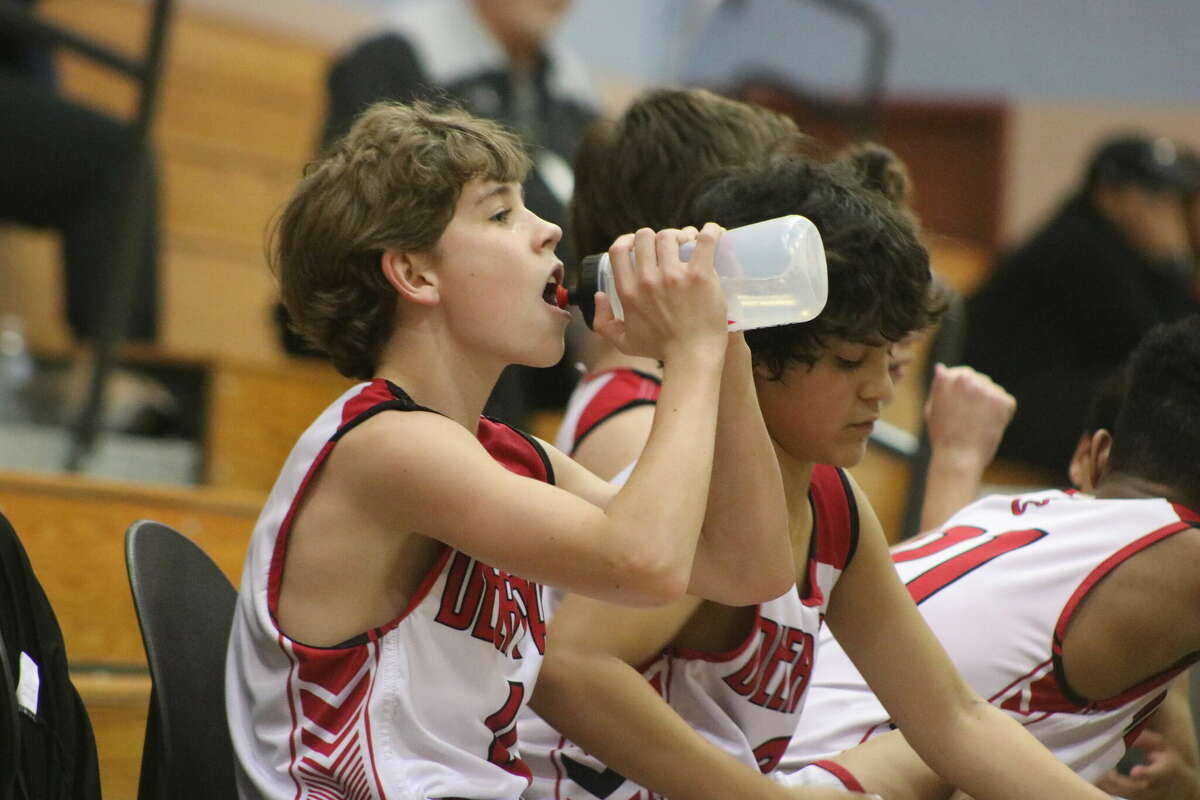 Fawns player Hayden Holton gulps down some water during a second-half timeout Friday night against La Porte Junior High in Pearland.