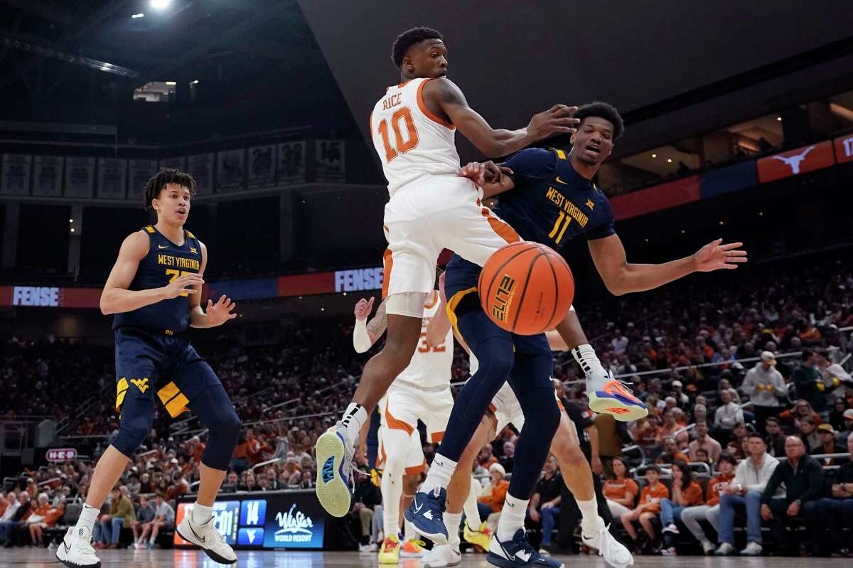 West Virginia forward Mohamed Wague (11) loses control of the ball as he is defended by Texas guard Sir'Jabari Rice (10) during the first half of an NCAA college basketball game in Austin, Texas, Saturday, Feb. 11, 2023. (AP Photo/Eric Gay)
