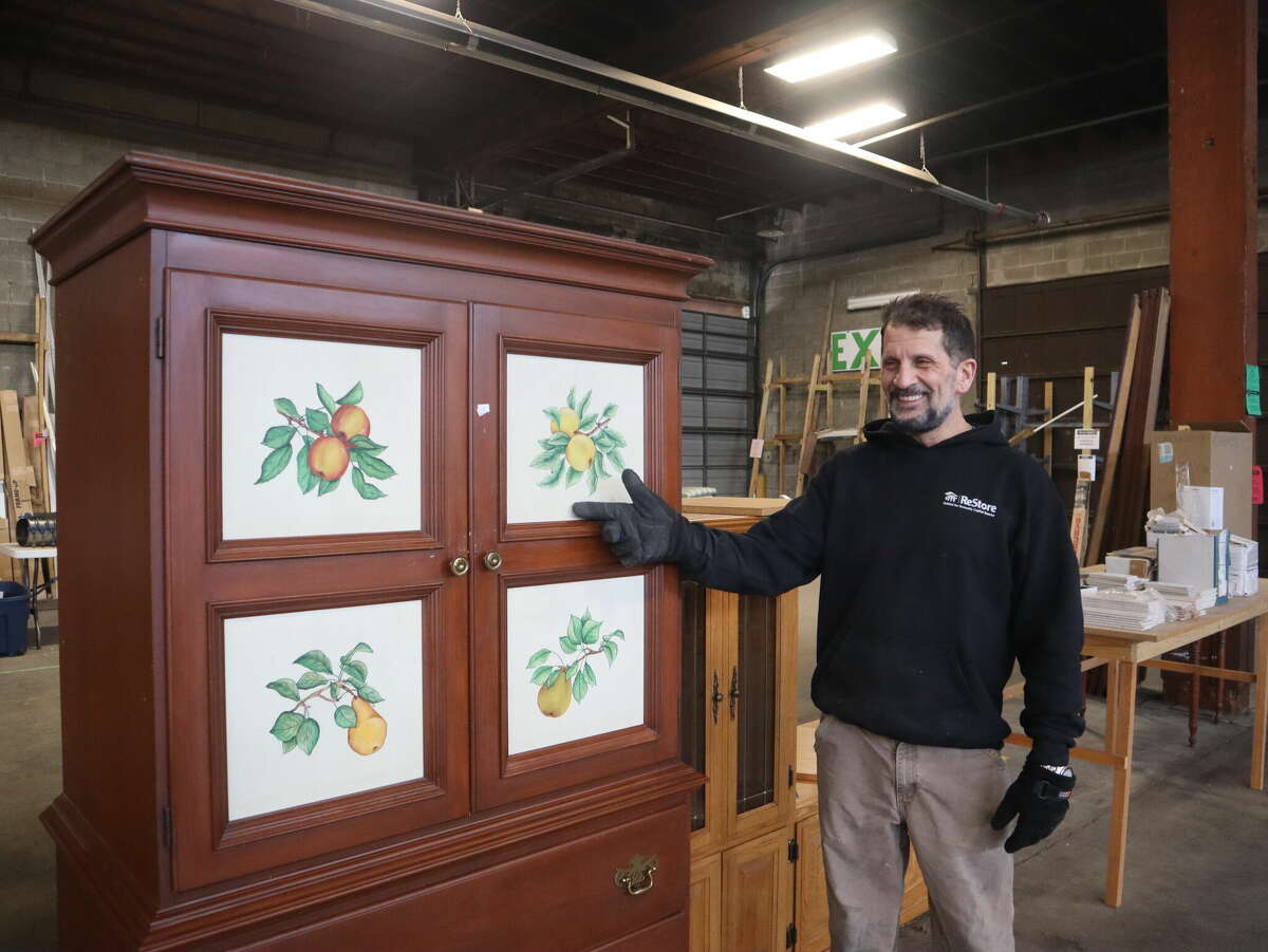 Raymond Garlock points out a cabinet formerly from the Desmond Hotel Saturday, Feb. 11, 2023 at the Habitat for Humanity ReStore in Albany.
