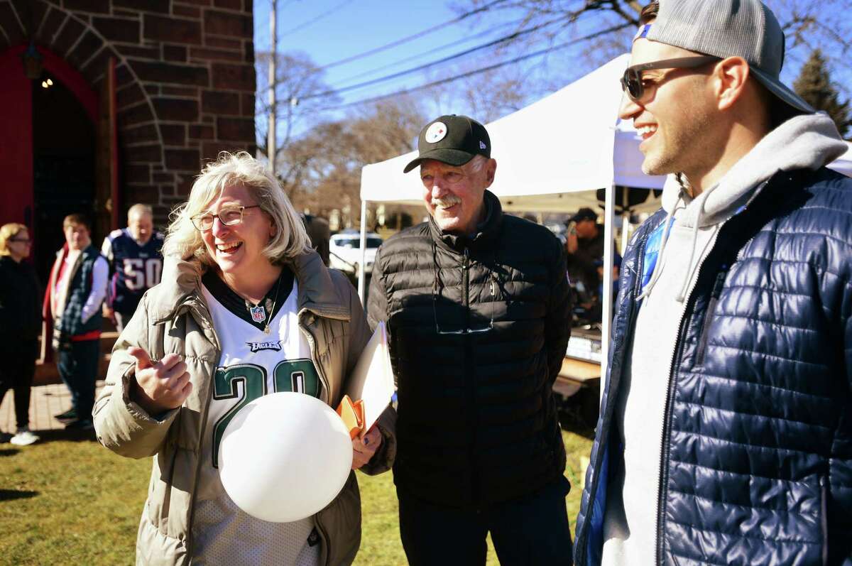 From left; Souper Bowl tailgating party organizer Rachel Merva, of Milford, laughs with former NFL football players Terry Hanratty, of the Pittsburgh Steelers, and Niko Koutouvides, of the New England Patriots, at the fundraiser for the Beth-El Center and Milford Food Bank at Mary Taylor Memorial United Methodist Chuirch in Milford, Conn. on Saturday, February 11, 2023.