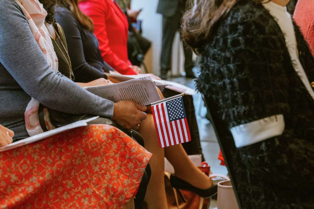 A participant holds an American flag at the naturalization ceremony.