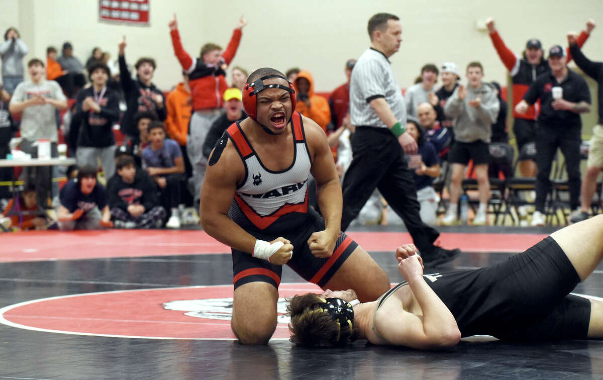 Nehemias Pettway of Warde celebrates after pinning Mike Gianetti of Trumbull in the 220-pound weight class final at the FCIAC wrestling tournament in New Canaan on Saturday, Feb. 11, 2023.
