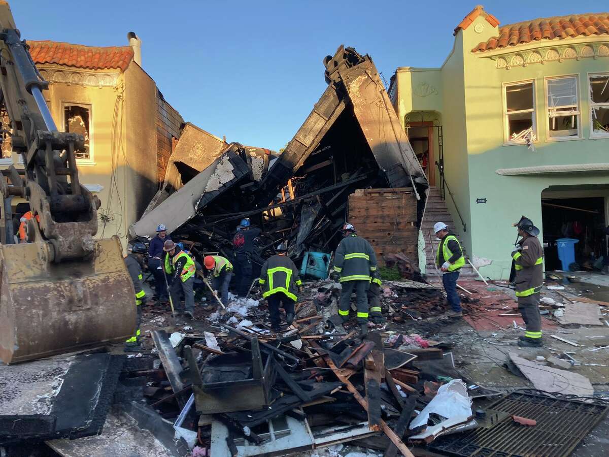 Firefighters sift through the rubble of a house that exploded in the Sunset District Thursday morning.