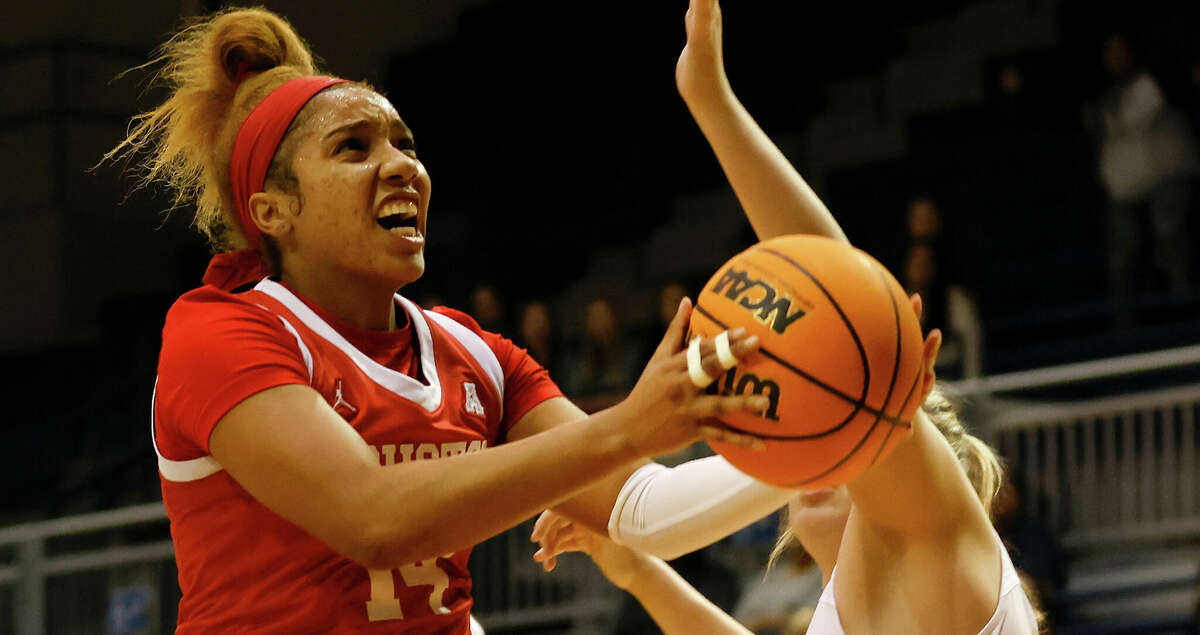 Houston Cougars guard Laila Blair (14) goes up for a lay up defended by Rice Owls forward Malia Fisher (1) and guard Haylee Swayze (11) during the NCAA women's basketball game between the Rice Owls and the Houston Cougars at Tudor Fieldhouse in Houston, TX on Saturday, December 10, 2022. The Cougars lead the Owls 39-29 at halftime.