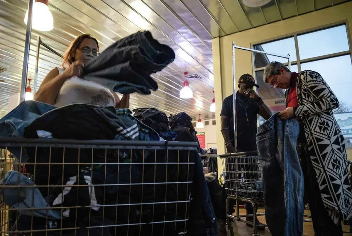Linda Jackson, Corey Roberson and Sasha Rose, an organizer with Austin Mutual Aid, fold clothing at the Washatopia laundromat in Austin on Feb. 7.