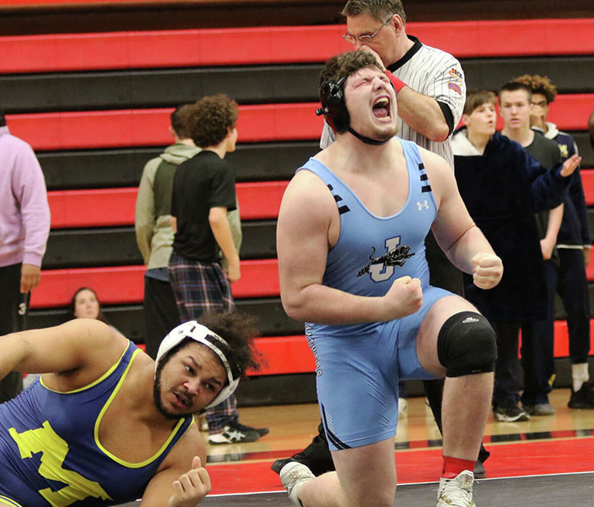 Jersey's Jaydon Busch (right) reacts after clinching a state trip by pinning Marion's Kanye Gunn 36 seconds into the second period of their a 275-pound match Saturday at the Highland Class 3A Sectional.