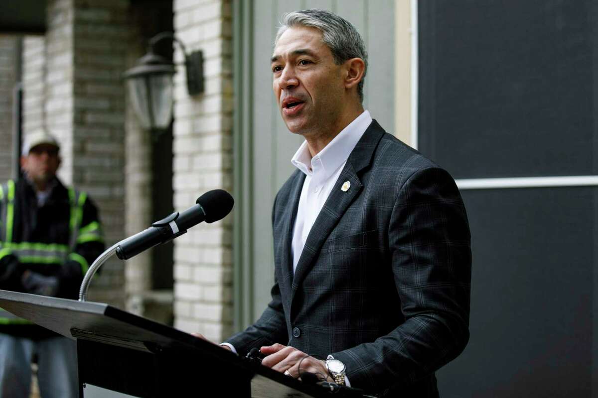 Mayor Ron Nirenberg addresses a large crowd as they stand outside of Janie Garcia’s home to celebrate CPS Energy’s milestone of upgrading 30,000 homes through the utility’s SaveNow Casa Verde Weatherization program.