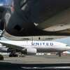 美国联合航空公司波音777是准备出发到火奴鲁鲁从门到另一架出租车向跑道(背景)SFO在旧金山,加州星期四,2020年10月15日。航空业认为适度增加旅游、快速COVID-19测试网站建立了机场为旅客提供文档的测试结果显示到达最终的目的地。