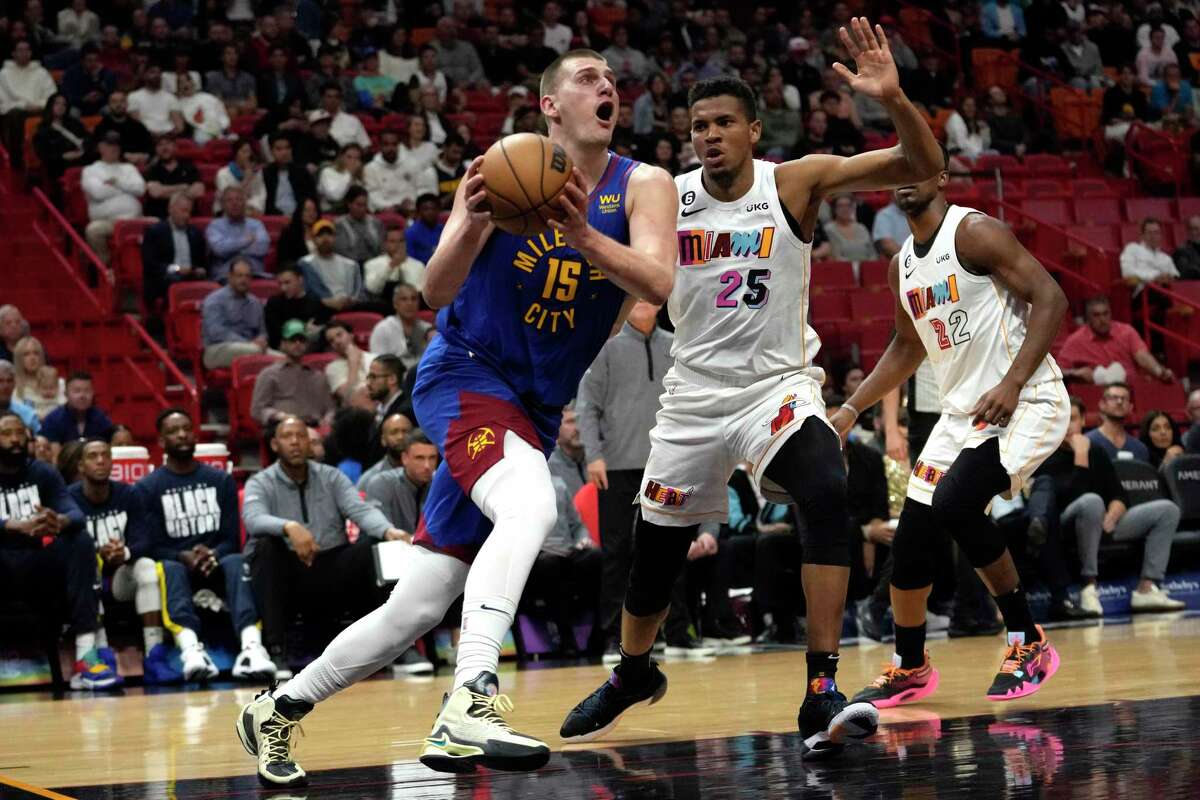 Denver center Nikola Jokic drives to the basket as Miami center Orlando Robinson tries to defend.
