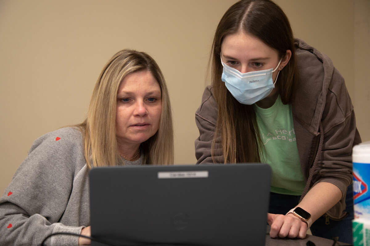 Volunteers Jana Stephenson, left, and Emma Bergman look over the data collected from an EKG on Monday, Feb. 13, at the Comstock Community Center in Wilton. 