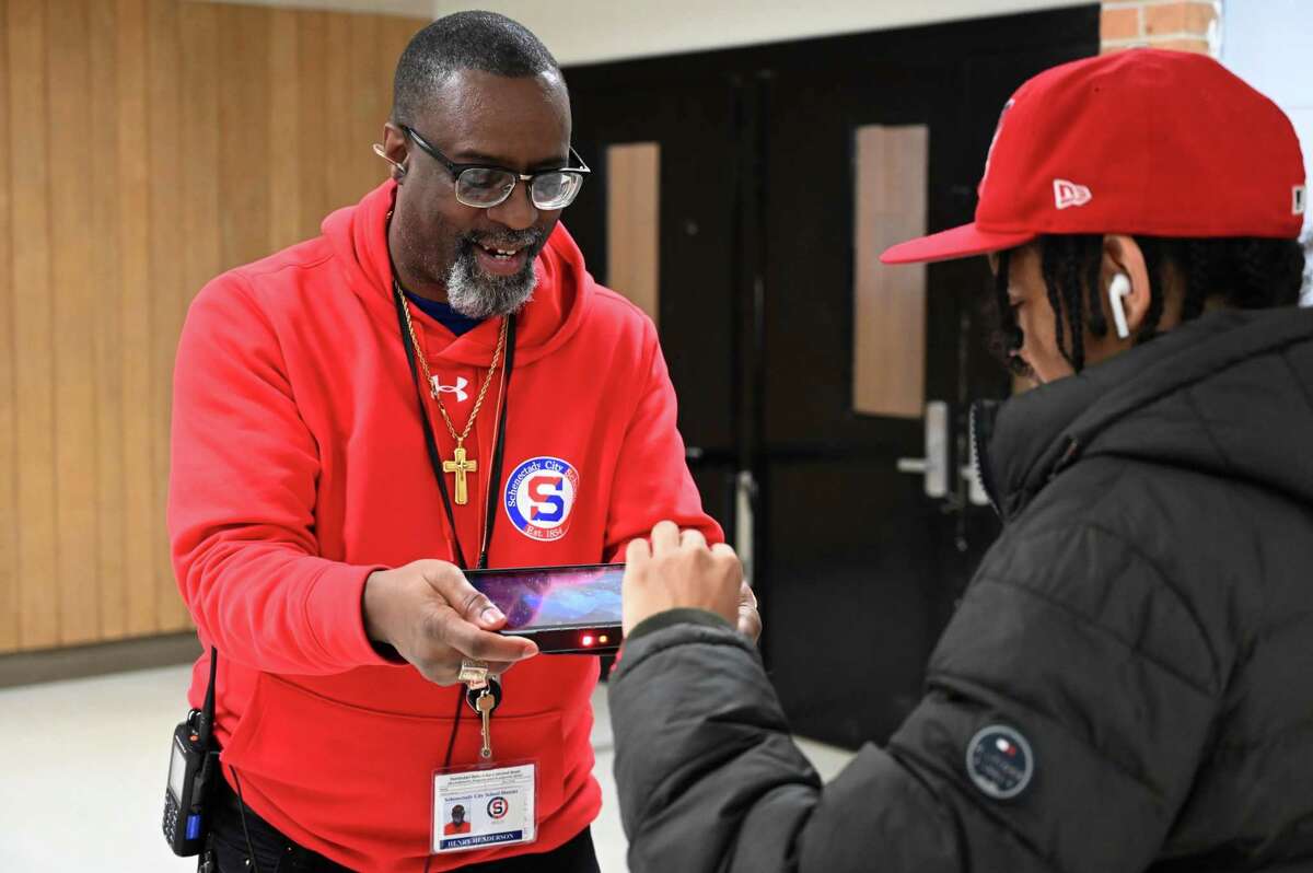 Schenectady High School security team member Henry Henderson scans a student’s ID, while holding station outside the cafeteria on Wednesday, Feb. 8, 2023, at Schenectady High School in Schenectady, N.Y.