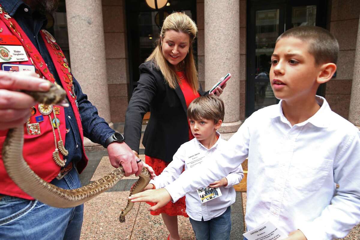 Texas State Rep. Terri Leo-Wilson, R-Galveston, and her grandchildren, Tate Hernandez, 5, and Leo Hernandez, 9, touch a rattlesnake handled by a member of the Sweetwater, Texas Jaycees at the State Capitol, Tuesday, Feb. 14, 2023. The Jaycees were promoting the annual Sweetwater Rattlesnake Roundup. The festival started in 1958 and continues this year starting on March 11 through March 13.