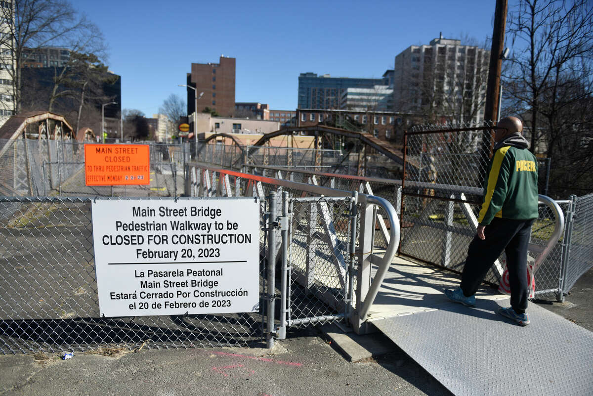 Pedestrians walk across the decrepit footbridge spanning the Rippowam River between Mill River Park and Mill River Playground in Stamford, Conn. Tuesday, Feb. 14, 2023. The bridge will close on Feb. 20 as construction work begins on a temporary replacement, just north of the existing structure.