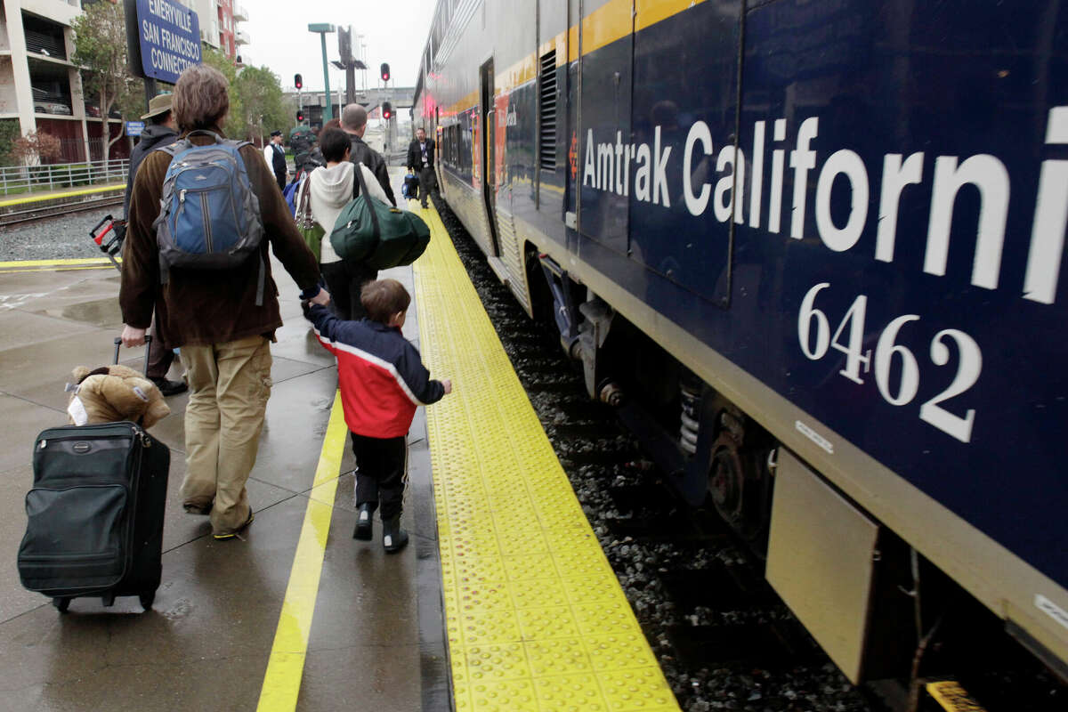 Barton Saunders and his son, Hayden Saunders, prepare to board the Capitol Corridor Amtrak train in Emeryville.