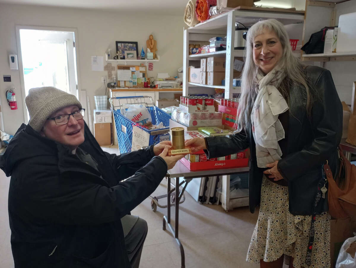 Baldwin Congregational Pastor Bruce Whitney (left) accepts the golden soup award from Lynne Mills, director of Bread of Life Food Pantry (right). 