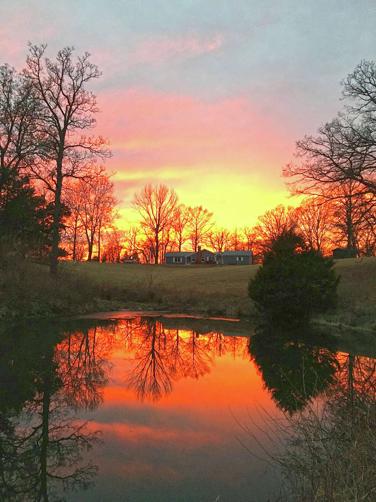 The vibrant colors of a winter sunset are reflected in a pond in Morgan County.