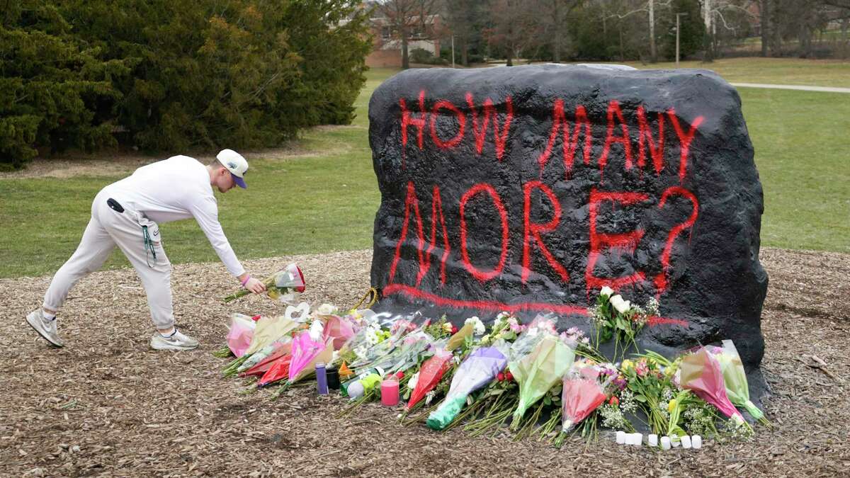 A student leaves flowers at The Rock on the grounds of Michigan State University, in East Lansing, Mich., Tuesday, Feb. 14, 2023. A gunman killed several people and wounded others at Michigan State University. Police said early Tuesday that the shooter eventually killed himself.