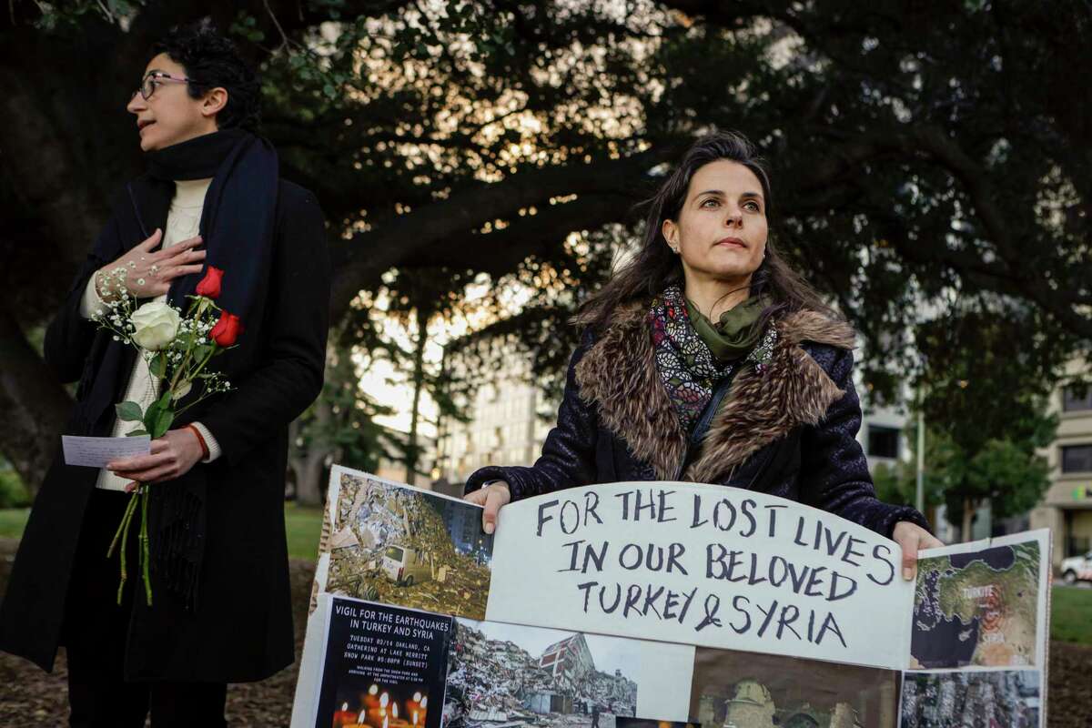 Nermin Soyalp holds a poster during a vigil in Oakland on Tuesday as she joins dozens in honoring the  thousands who have died and thousands injured in the 7.8 earthquake that shook Turkey and Syria on Feb. 6. Soyalp and fellow therapist, Kholoud Nasser organized the gathering and marched from Oakland’s Snow Park to the amphitheater at Lake Merritt.