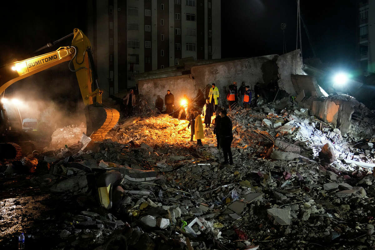 Emergency teams search for people in the rubble of a building in Adana, Turkey, destroyed in a powerful earthquake on Feb. 6, 2023. 